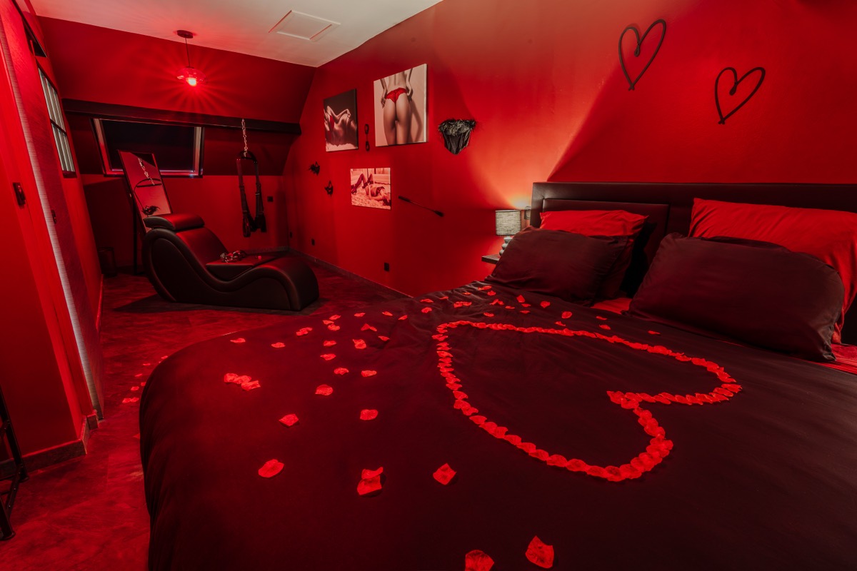 Chambre romantique avec lit XL et pétales de rose en cœur — love room L'Inavouable à Marquise