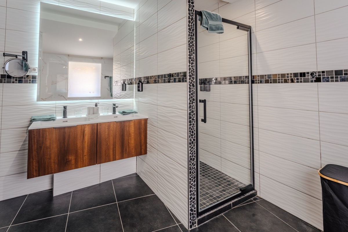 Salle de bain spacieuse avec sèche-serviettes et rangements — L'Inavouable à Marquise