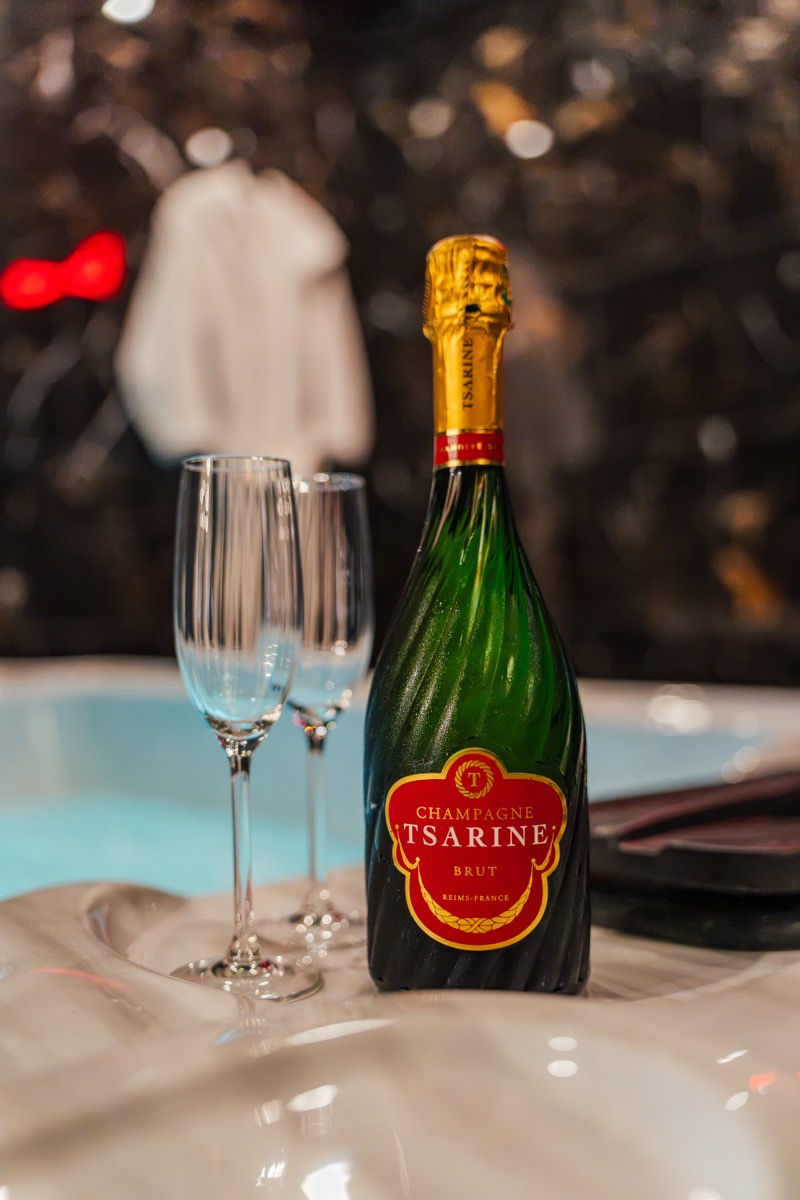 Champagne au bord du jacuzzi privatif — love room L'Inavouable à Marquise