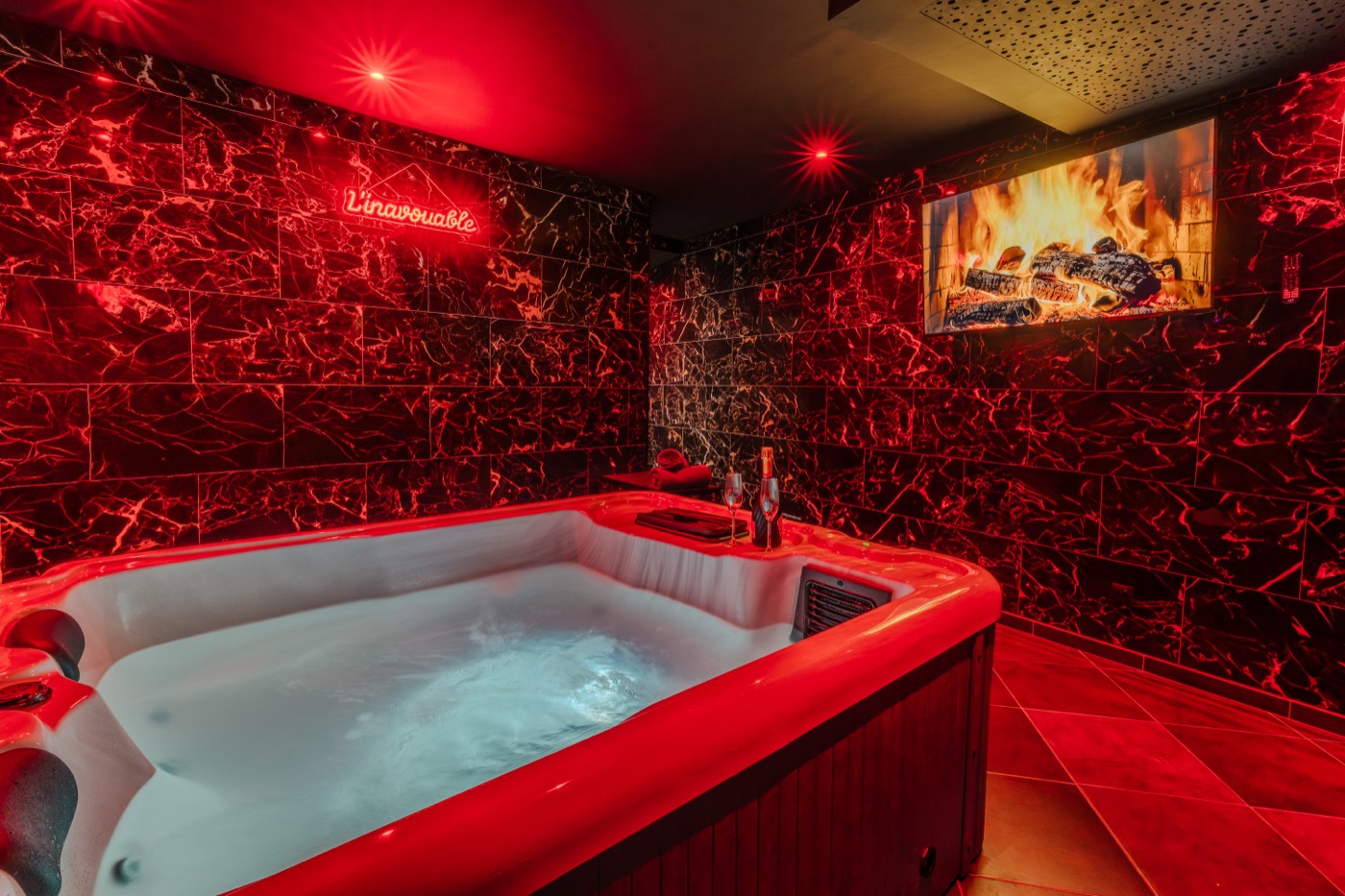 Jacuzzi privatif en ambiance rouge tamisée — love room L'Inavouable à Marquise